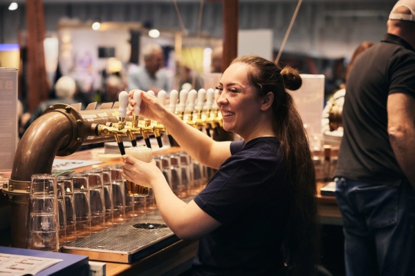 Servis som häller upp öl vid en öltapp