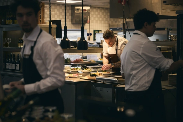 Kock som förbereder mat i kök, servis vid kassalinjen